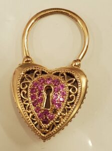 A gold locket with pink stones