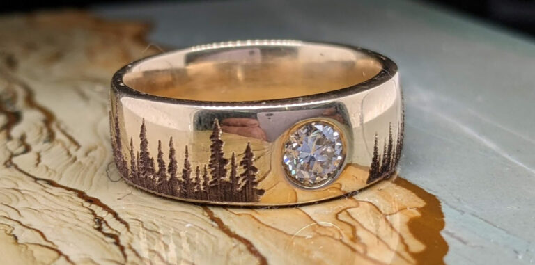 An engraved diamond gold wedding band with engraved trees