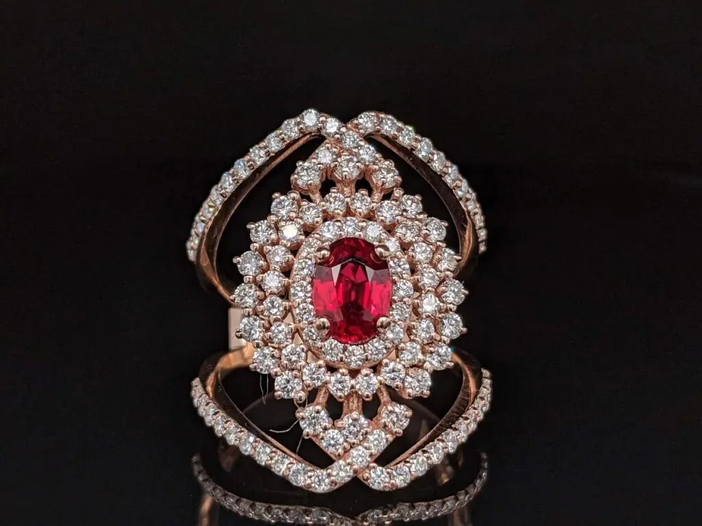 Gold ring with a red stone and diamond designs