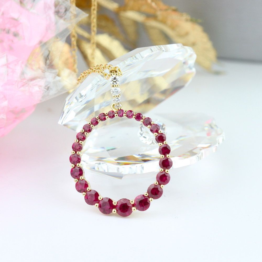 A circle pendent made up of red gem stones on a gold chain