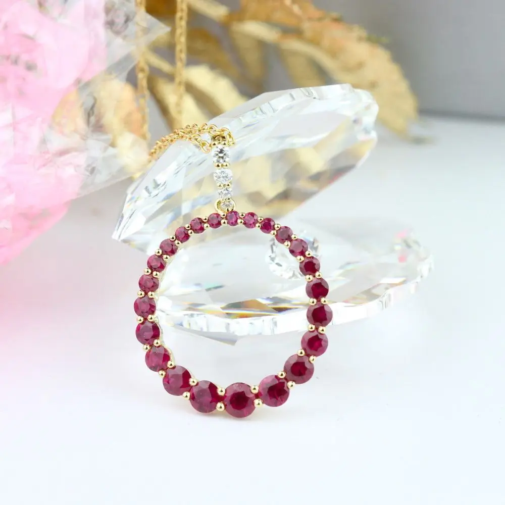 A circle pendent made up of red gem stones on a gold chain